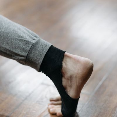 Close-up of a person's feet on a yoga mat, suggesting grounding and stability.